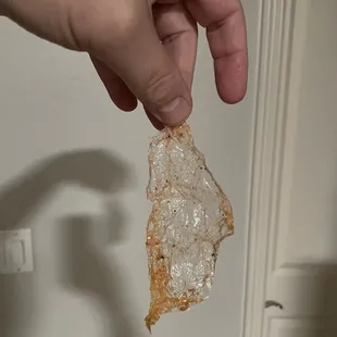 a hand holding a piece of pizza