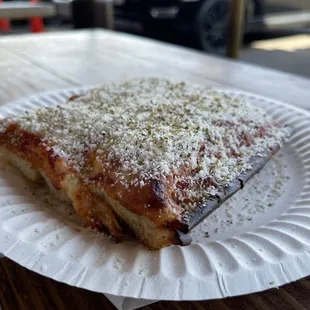 Sicilian Pizza Slice with Parmesan cheese added / oregano flakes