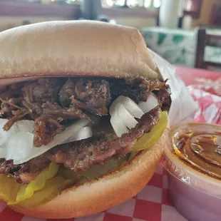 a pulled pork sandwich with pickles and onions