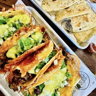 two trays of tacos and tortillas