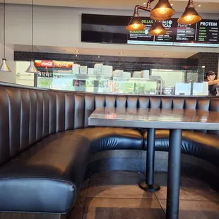 a corner booth with a table and chairs