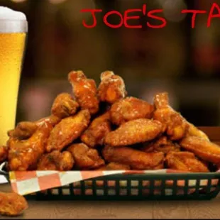 a basket of chicken wings and a glass of beer