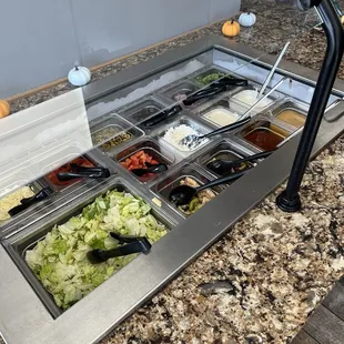 a salad bar with a variety of toppings
