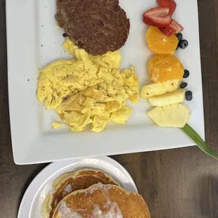 a breakfast of pancakes, eggs, fruit, and pancakes