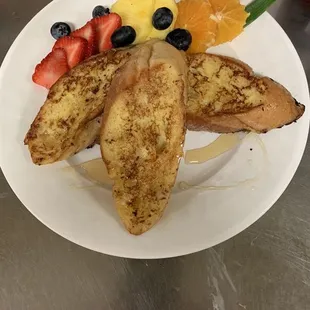 a plate of french toast with fruit
