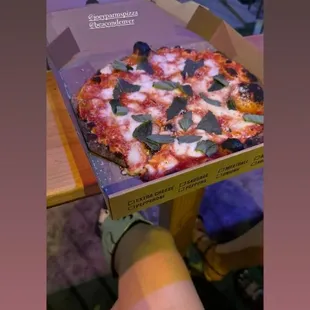 someone holding a box of pizza