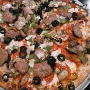 Deluxe Famous recipe pizza sauce, pepperoni, mushrooms, green peppers, onions, black olives, sausage, and provolone cheese.
