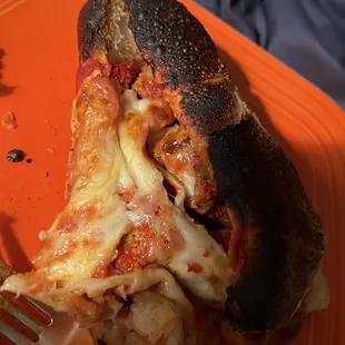 a slice of pizza on an orange plate