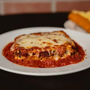 Lasagna served with a side of garlic bread.