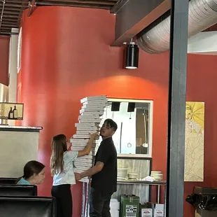 a man handing a pizza to a woman