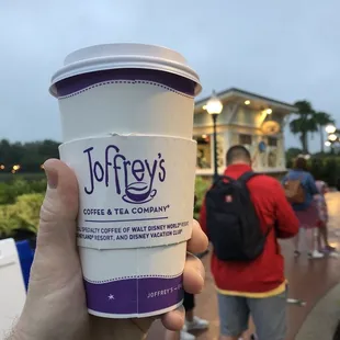 a hand holding a cup of coffee