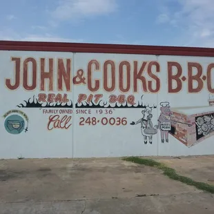 a painted sign for john &amp; cook&apos;s bbq