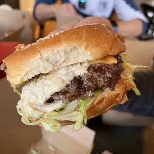 a hamburger being held by a man