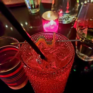 a red drink with a straw in a glass