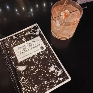 a drink and a notebook on a table