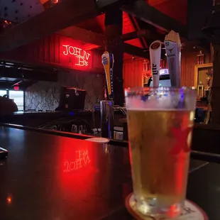 a glass of beer on a bar