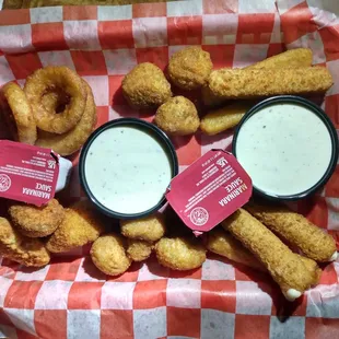 a tray of fried donuts and dipping sauces