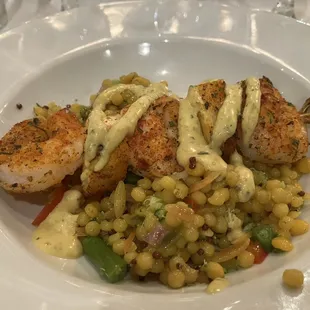 Shrimp and pineapple skewer on top of couscous