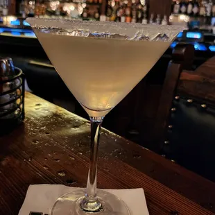 a martini sitting on a napkin at a bar