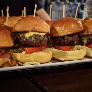 a platter of hamburgers with toothpicks
