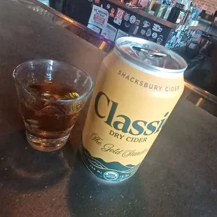 a glass of whiskey and a can