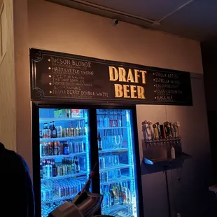 a man standing in front of a draft beer fridge