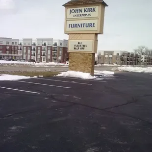 Large sign by entrance to parking lot.