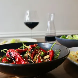 a bowl of food and a glass of wine