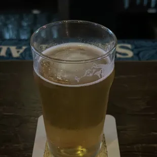 a glass of beer on a coaster