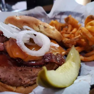 a burger with onion rings and a pickle