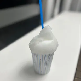 a frosted cupcake with a blue straw