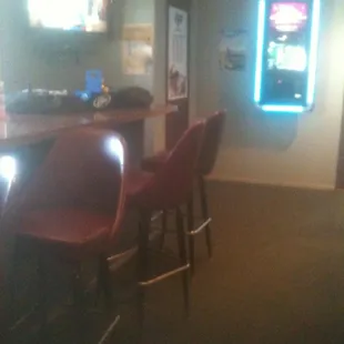 a bar with red chairs