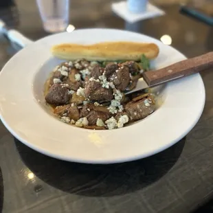 Steak tips appetizer with caramelized onions, blue cheese, mushrooms and rocket leaves.  Delicious!