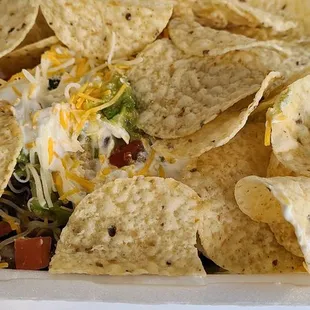 Salad bowl with tortilla chips on top and choice of meat was firecracker chicken. Guacamole and queso always included!