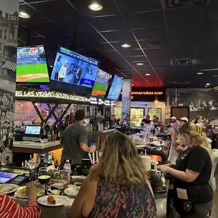 Inside bar area w/comfy looking barstools and tons of TVs