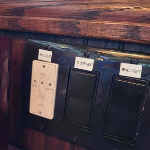three switches on a wooden wall