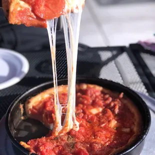 a piece of pizza being lifted by a spatula