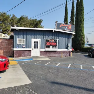 a red car parked in front of the restaurant