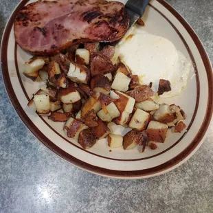 Egg over medium, ham, with American fries, toast.