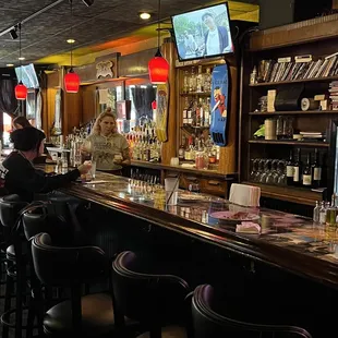 a bar with people sitting at the bar