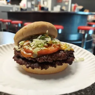 a hamburger on a paper plate