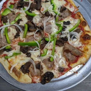 a pizza with mushrooms, peppers, and onions