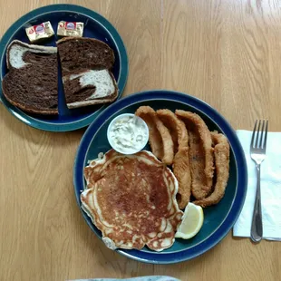 two plates of pancakes and onion rings