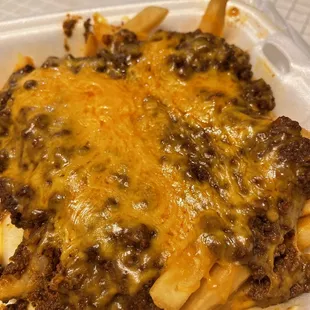 a cheeseburger fries in a styrofoam container