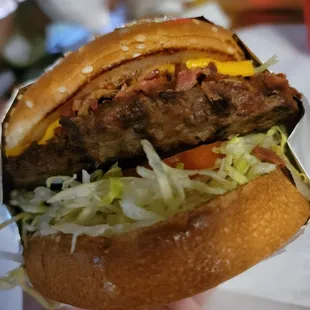 a hand holding a hamburger