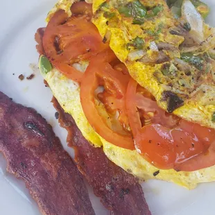 Vegetable omlet with spinach, tomatoes, mushrooms, and onions, accompanied by turkey bacon.