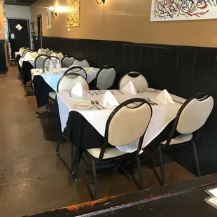a row of tables with white tablecloths