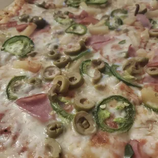 Our jalapeno, ham, and pineapple pizza covered in and ingredient we did not order - green olives.