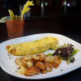 an omelet, potatoes, and salad