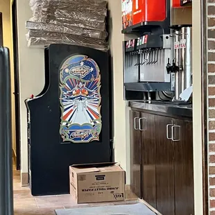 a kitchen with a refrigerator and a pizza box